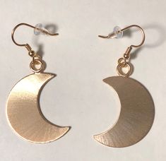 I've designed a pair of crescent moon earrings, 1 1/8 inches each in size, with dangling ear hook wires. The set is completely handmade in sterling silver. Inspired by Stevie Nicks, I wanted to fabricate matching earrings to the moon pendant and as this was for a customer request, I thought, what a grand idea! I can offer a 24K gold plating option that I will include in the drop down menu at checkout! The last image is to show the crescent moon necklace. Please convo for any questions! Allow me Gold Crescent Earrings With Moon Phase Detail, Metal Moon-shaped Hoop Earrings, Gold Half Moon Earrings With Moon Charm, Metal Crescent Moon Phase Earrings, Nickel-free Crescent Celestial Earrings, Brass Earrings With Moon Charm In Half Moon Shape, Celestial Half Moon Phase Earrings, Celestial Crescent Moon Phase Earrings, Metal Half Moon Earrings With Moon Charm