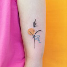 a small flower tattoo on the left arm