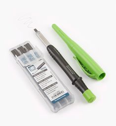 a green pen and some other items on a white surface