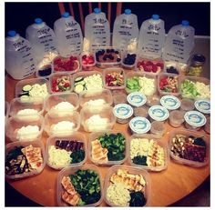 a table topped with lots of plastic containers filled with different types of food and drinks