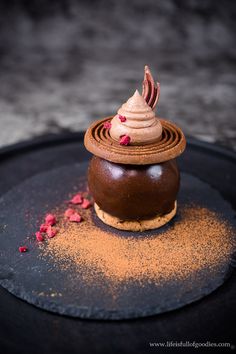 a chocolate dessert is sitting on a black plate