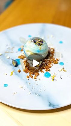 a white plate topped with a desert covered in blue and gold sprinkles