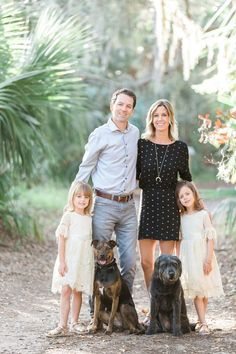 a family posing for a photo in the woods with their dogs