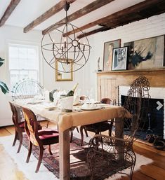 a dining room table with chairs and a chandelier hanging from it's ceiling