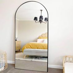 a bedroom with a large mirror on the wall