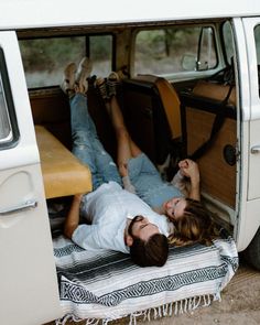 two people laying in the back of a van with their feet up on each other