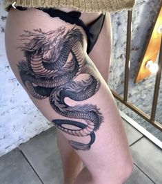 a woman's thigh with a dragon tattoo on it