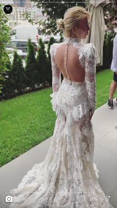 the back of a woman's wedding dress is shown in front of some people