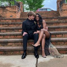 a man and woman are sitting on some steps