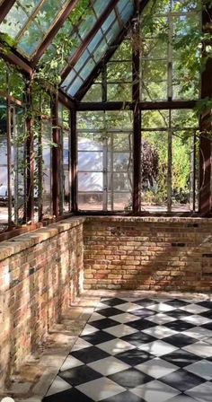 the inside of a building with many windows and plants growing on the outside side of it