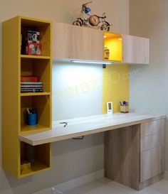 an office desk with yellow shelving unit in the middle and shelves above it on either side