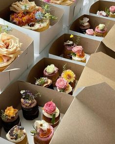 there are many cupcakes in the boxes with flowers on them and one is missing