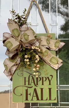 a happy fall sign hanging from the side of a building