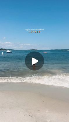 a beach with waves and boats in the water