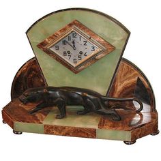 an art deco clock with a black cat on it's side and a green background