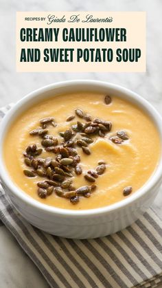 creamy cauliflower and sweet potato soup in a white bowl on a striped napkin