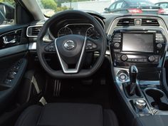 the interior of a car with dashboard, steering wheel and dash lights on display in a parking lot