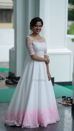 a woman in a white and pink dress posing for the camera with her hands on her hips