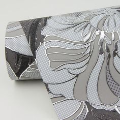 a close up of a tie on a white surface with grey and black designs in the background