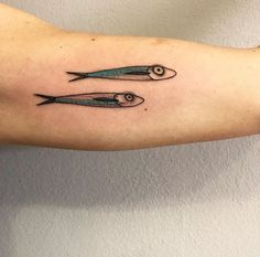 two small fish tattoos on the arm