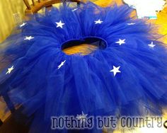 a blue tutu with white stars is sitting on a table next to a chair