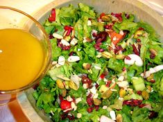 a salad in a bowl next to a glass of orange juice