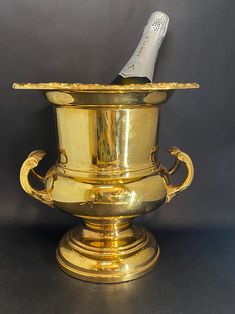 a gold vase with a bottle in it