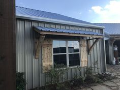 a small metal building with a blue tin roof