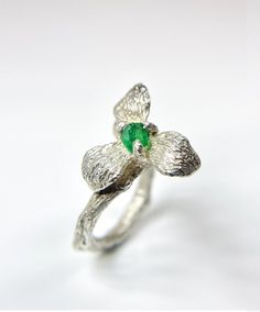 Introducing our stunning handmade flower ring with a textured branch band, featuring a raw stone in vivid green emerald, blue tanzanite, or red spinel. Inspired by nature, every part of the ring is intricately carved with texture for a realistic look. The textured branch band wraps around your finger like a blossoming tree branch, adding a boho and rustic vibe to any outfit. This statement piece is perfect for any occasion, from casual outings to special events, even as an engagement or wedding ring. Note that blue is ready to ship, while green and red are customizable made-to-order. -Gems Informations Uncut Swat emerald/ tanzanite/ spinel  -Ring size Adjustable width of band: 2.3- 3.2mm -Materials 925 silver Please note that silver will naturally oxidize over time, resulting in a beautifu Unique Green Flower Ring, Nature-inspired Emerald Ring For May Birthstone, Nature-inspired Emerald Ring, Nature-inspired Green Flower Ring As A Gift, Nature-inspired Green Flower Ring For Gift, Nature-inspired Green Flower Ring As Gift, Surprise Box Gift, Raw Emerald, Red Spinel