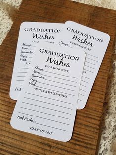 three graduation wishes cards sitting on top of a wooden board