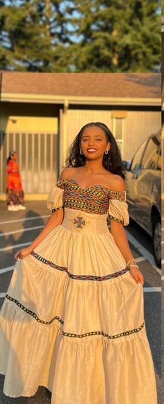 a woman in a white dress standing next to a car