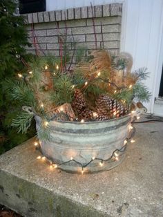 a planter filled with pine cones and lights