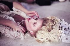 a woman laying on the floor with headphones in her ears