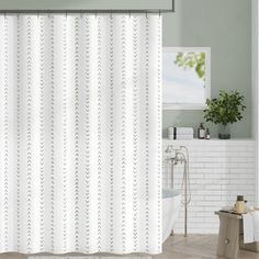 a white shower curtain with green leaves on it