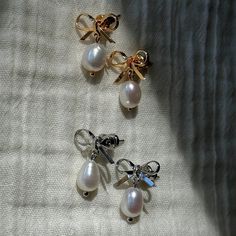 THE PRICE IS FOR A PAIR OF EARRINGS. These coquette stud earrings have a dainty pearl drop with a bow design a top it in gold or silver shade, making it an indispensable accessory for everyday wear and special occasions. These small earrings are often purchased by brides whether for themselves or for bridesmaids because they are super delicate, minimalist and elegant. And they also complement the clean girl aesthetics.  This item makes for a wonderful gift for her (mother, daughter, girlfriend). Wedding Pearl Drop Earrings With Bow, White Pearl Earrings With Bow For Wedding, Dainty Silver Pearl Earrings For Gift, Silver Feminine Earrings With Pearl Charm, Feminine Silver Earrings With Pearl Charm, Feminine Silver Pearl Drop Earrings, Silver Feminine Pearl Earrings For Anniversary, Feminine Silver Pearl Earrings For Anniversary, Dainty Pearl White Bridal Earrings For Gift