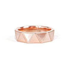 a rose gold ring with triangles on it