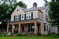 a two story house sitting on top of a lush green field