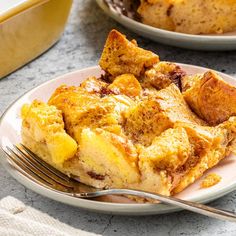 a piece of bread pudding on a plate with a fork next to the rest of the dish