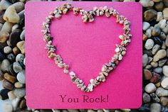 a pink card with a heart made out of shells and the words you rock on it