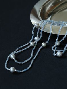 This elegant necklace features a long strand adorned with natural aquamarine and gray pearls, exuding a sophisticated charm. Perfect for adding a touch of refinement to any ensemble, it combines the serene hues of aquamarine with the timeless allure of gray pearls, creating a versatile accessory suitable for both casual and formal occasions. Metal: Recycled Sterling Silver Plated On Brass Gemstone: Aquamarine Pearl: Freshwater Pearls 9-10mm Chain Length: 1400-1450mm Weigth: 29g Necklaces Pearl, Gemstone Beaded Necklace, Long Beaded Necklace, Elegant Necklace, Tiger Eye Stone, Elegant Necklaces, Pearl Grey, Natural Aquamarine, Recycled Sterling Silver