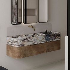 a bathroom sink sitting under two mirrors next to a wall mounted faucet in front of a mirror