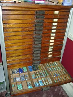 an old wooden cabinet with many different types of tiles on the front and side shelves