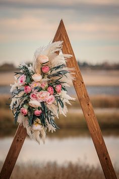 a wedding arch with flowers and feathers on it