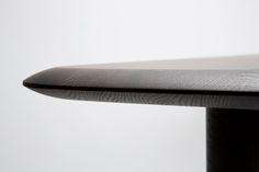 a close up view of the top of a table with a curved edge and black metal base