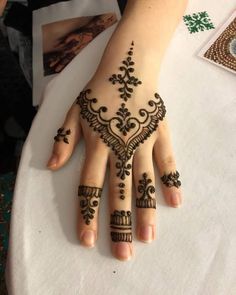 a woman's hand with henna tattoos on it