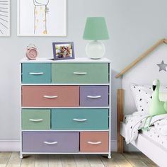 a child's bedroom with colorful drawers and pictures on the wall