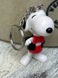 a keychain shaped like a cartoon dog with a red collar and black eyes