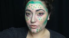 a woman with green and white face paint on her face is looking at the camera