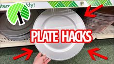 a person holding a plate with the words plate hacks on it in front of stacks of plates