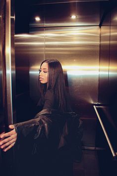 a woman standing in front of an elevator